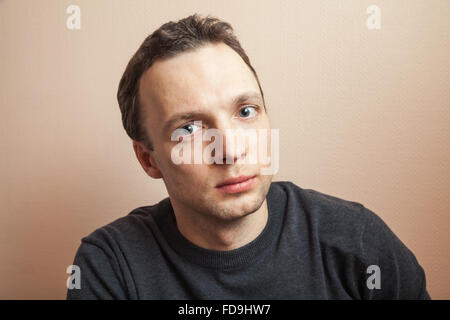 Les jeunes beau positive man closeup portrait sur fond de mur gris Banque D'Images