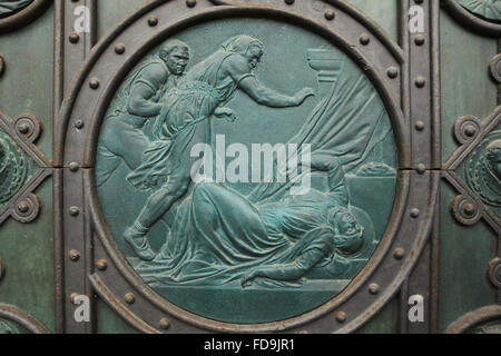 Assassinat de Saint Ludmila. Relief en bronze conçue par l'artiste tchèque Josef Mánes sur la porte principale de l'église des Saints Cyrille et Méthode sur Karlinske square dans le quartier de Karlin à Prague, République tchèque. Banque D'Images