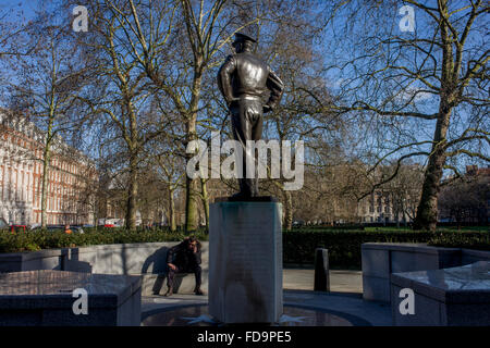 Un homme parle dans son téléphone en bas de la statue au général Dwight D. Eisenhower devant l'ambassade américaine à Grosvenor Square, Londres. Banque D'Images