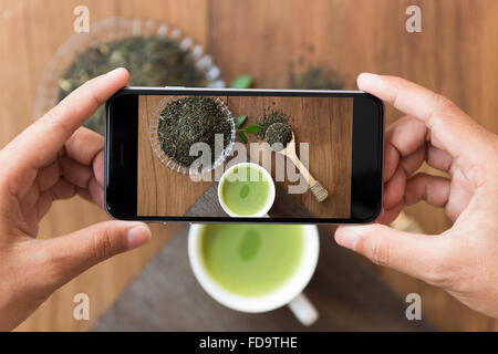 Main libre holding phone shooting verre photo Banque D'Images