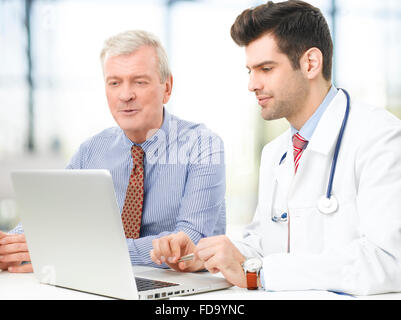 Beau jeune médecin à expliquer les résultats d'un patient. Banque D'Images