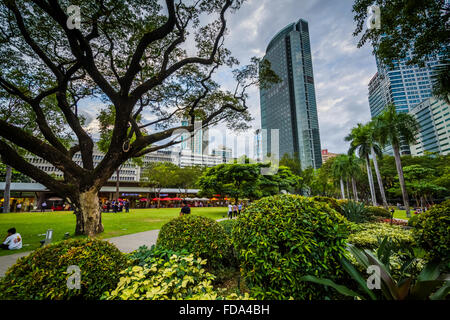 Jardins et des gratte-ciel vu à Ayala Triangle Park, à Makati, Metro Manila. Banque D'Images