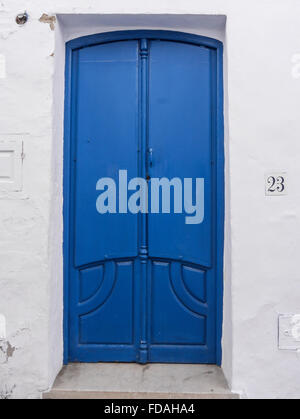 Double porte bleue à quatre panneaux - deux décoratives et deux petites poignées métalliques simples, Frigiliana, Malaga, Andalousie, Espagne. Banque D'Images