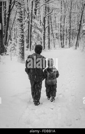 Deux frères prendre une marche dans un sentier dans une tempête de neige. Banque D'Images