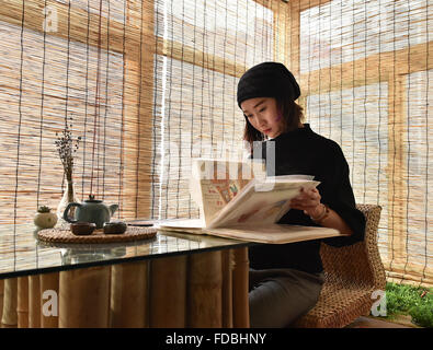 Taiyuan, la province de Shanxi. 29 janvier, 2016. Illustrator alimentaire Wang Anjing lit ses œuvres à Taiyuan, capitale du nord La province de Shanxi, le 29 janvier 2016. Wang utilise cartoon illustrations d'introduire de la nourriture traditionnelle de sa ville natale Taiyuan comme elle a terminé première œuvres graphiques en juillet 2015. © Cao Yang/Xinhua/Alamy Live News Banque D'Images