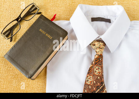 Le pasteur vêtements et Sainte Bible avec lunettes à la maison. Aller à l'église chrétienne ou de concept. Banque D'Images