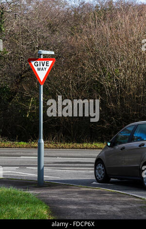 Une façon donner signe de route avec une voiture s'est arrêtée à l'arrêt de la jonction. Banque D'Images