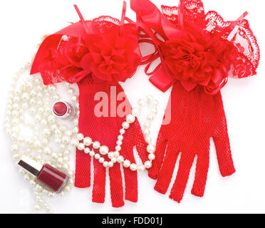 Gants rouge et d'autres accessoires - pearl, vernis à ongles, rouge à lèvres. Fond blanc Banque D'Images