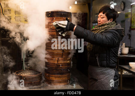 Xi'an, Chine. Janvier, 2016 - une dame à la vapeur cuisson boulettes dans un marché au quartier musulman. Banque D'Images