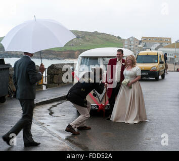 Jeunes mariés photographié devant un bus VW Volkswagen Vintage ca. Oa 1965 un jour de pluie à St Ives Cornwall UK Europe Banque D'Images