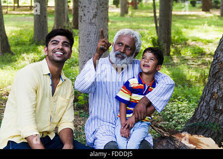 3 Personnes Grand-père fils et petit-fils Park sitting pointer du doigt montrant Banque D'Images