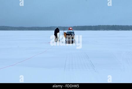 Lake Oulujarvi, lac Oulujarvi. 27 Jan, 2016. Pentti, un 60-year-old pêcheur sur glace, perce un trou sur le lac Oulujarvi, janv. 27, 2016. Il y a environ 180 mille lacs en Finlande. Certains pêcheurs qui vivent près des lacs aller à la pêche sur glace pour vivre en hiver. © Li Jizhi/Xinhua/Alamy Live News Banque D'Images