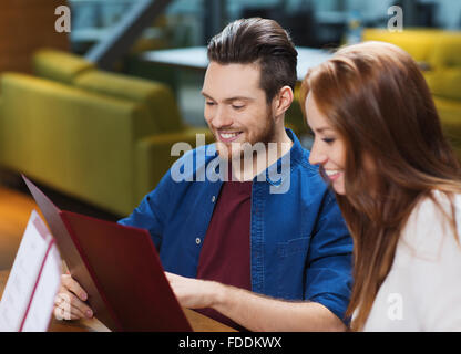 Smiling couple avec des menus au restaurant Banque D'Images