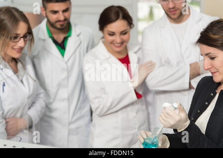 Groupe d'étudiants qui effectuent des recherches scientifiques avec l'enseignant dans un environnement de laboratoire Leçons d'apprentissage en classe - Pour obtenir de l'aide et Sup Banque D'Images