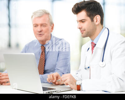Beau jeune médecin à expliquer les résultats d'un patient. Banque D'Images