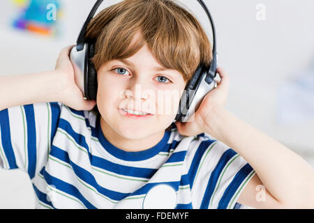 Cute boy portant des écouteurs et écouter de la musique Banque D'Images