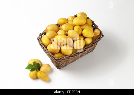 Les pommes de terre en frais panier en osier marron sur fond blanc Banque D'Images