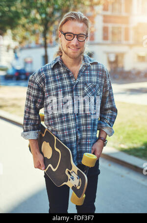 Portrait de jeune homme, Ville de vie, portant son skateboard Banque D'Images