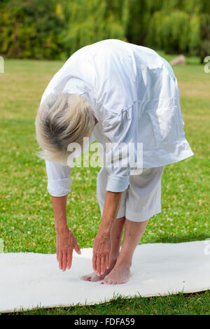 Vieux en bonne santé senior woman practicing yoga et tai chi outdoor Banque D'Images
