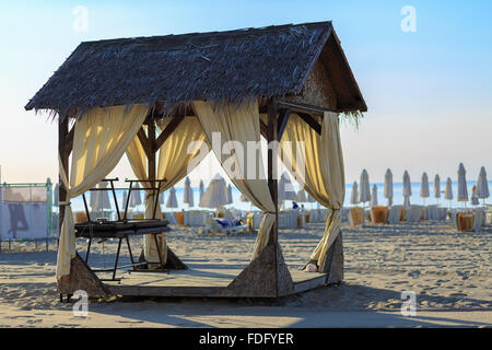 La canopée massage avec toit de chaume sur la plage de sable. Tôt le matin. Profondeur de champ. Focus sélectif. Banque D'Images