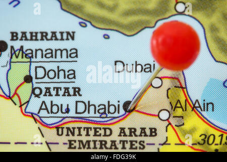 Close-up d'une punaise rouge dans une carte d'Abu Dhabi, Émirats arabes unis. Banque D'Images