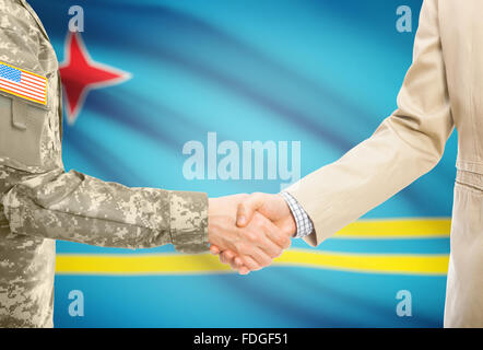 Soldat américain en uniforme et civils man shaking hands with drapeau national sur l'arrière-plan - Aruba Banque D'Images