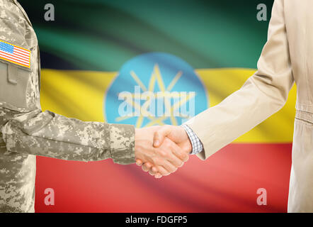 Soldat américain en uniforme et civils man shaking hands with drapeau national sur l'arrière-plan - Ethiopie Banque D'Images