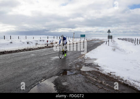 Cycliste solitaire à travers la circonscription un couvert de neige635 moors road à Bellevue au Yorkshire Banque D'Images