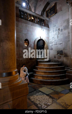 Un pèlerin chrétien situé au pied de l'escalier grimpant au Calvaire ou au Golgotha traditionnellement considéré comme le site de la crucifixion de Jésus et la partie la plus somptueusement décorée de l'église du Saint sépulcre dans la vieille ville de Jérusalem Israël Banque D'Images