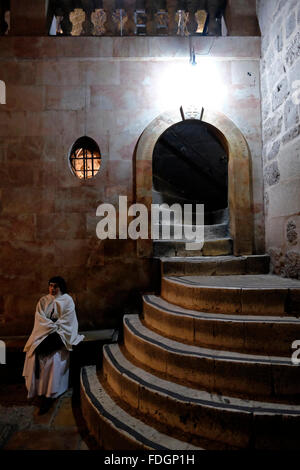 Un pèlerin chrétien situé au pied de l'escalier grimpant au Calvaire ou au Golgotha traditionnellement considéré comme le site de la crucifixion de Jésus et la partie la plus somptueusement décorée de l'église du Saint sépulcre dans la vieille ville de Jérusalem Israël Banque D'Images