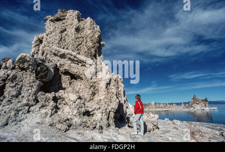 Une énorme formation de tuf est vue de près par une visiteuse au lac Mono tuf État réserve en Mono County, Californie, USA. Soi-disant "tufa towers' sont créés lors de l'interaction avec les sources d'eau douce du lac alcalin de l'eau pour former des boutons et clochers de carbonate de calcium qui s'élèvent au-dessus de l'ancien lac. Le lac Mono est plus d'un million d'années et n'a aucun débouché. Banque D'Images