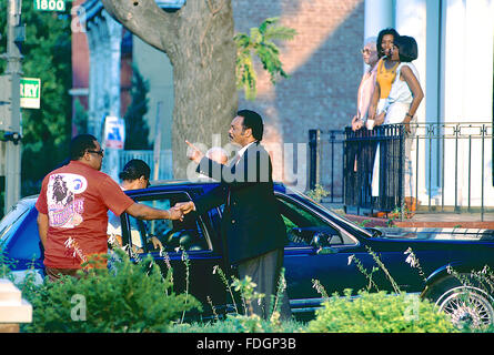 Washington, DC, USA, 1988. Le révérend Jesse Jackson arrive à la maison d'une campagne présidentielle voyage et serre la main à un voisin. Alors que sa mère, épouse et fille l'attendre à l'avant l'étape de sa maison de Washington DC. Jesse Louis Jackson, Sr. est un militant des droits civiques aux États-Unis et pasteur baptiste. Il était candidat à l'investiture démocrate à la présidence en 1984 et 1988 et a servi comme une ombre Sénateur des États-Unis pour le District de Columbia de 1991 à 1997. Il est le fondateur des organisations qui ont fusionné pour former Rainbow/PUSH. Credit : Mark Reinstein Banque D'Images