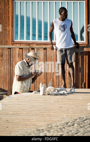 Portrait vertical d'hommes tortue carving chiffres au Cap Vert. Banque D'Images