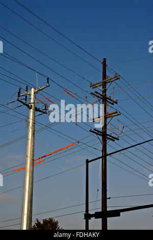 Topeka, Kansas, USA, 17 Septembre, 2014 Le nouveau polonais et les vieux mâts avec les lignes électriques entre eux. Un énorme projet d'énergie Westar Topeka soulève quelques sourcils dans plusieurs quartiers. Les poteaux de transmission massive l'utilitaire est installé pour remplacer le vieillissement, poteaux en bois existant.Les polonais sont 11 étages et environ cinq pieds de diamètre. Le plus grand peut accueillir des poteaux d'éclairage public LED plus efficace, ce qui permet d'économiser en moyenne de 40 à 50 pour cent par rapport aux options de sodium à haute pression. Credit : Mark Reinstein Banque D'Images