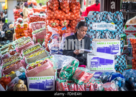 Femme vente de produits à la vente en gros de Manzini Produire et marché artisanal au Swaziland, Afrique. Banque D'Images