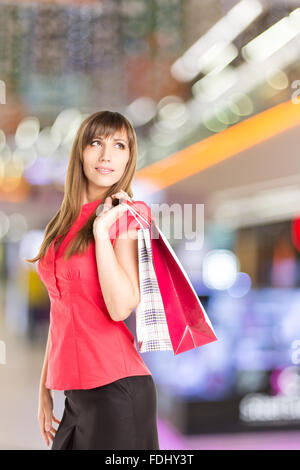 Jeune femme avec des sacs de shopping dans le centre commercial. Banque D'Images