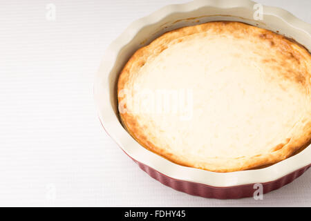 Gâteau au fromage au four dans un moule à gâteau en céramique sur la table avec l'exemplaire de l'espace. Recette gâteaux de cuisson ou l'arrière-plan du menu Banque D'Images