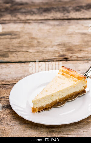 Gâteau au fromage blanc de Wedge sur soucoupe avec copie espace sur fond de bois Banque D'Images