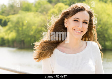 Jeune femme avec de longs cheveux noirs bouclés s'amuser sur l'été à l'extérieur. Happy smiling girl avec des dents en haut blanc Banque D'Images