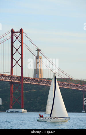 Voilier sur le Tage et le 25 avril pont à fond, Lisbonne, Portugal Banque D'Images