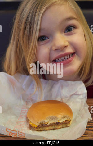 Adorable girl ont repas au fast food restaurant Banque D'Images