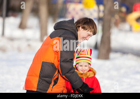 Les enfants dans le parc d'hiver s'amuser et jouer de boules Banque D'Images