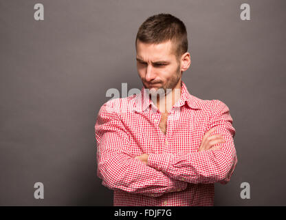 Homme posant avec bras croisés en studio Banque D'Images