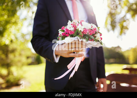 Le groom holding bouquet de mariage pour son épouse dans le jour du mariage Banque D'Images