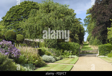 Double vue le long des frontières herbacées, sur la route, vers l'avenue de l'autre côté, du jardin créé par Simon Sainsbury et Stewart Grimshaw à Woolbeding House, West Sussex. Banque D'Images