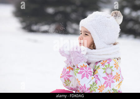 Girl blowing poignée de neige Banque D'Images