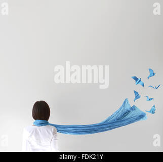 Vue arrière du femme avec foulard bleu et les oiseaux d'origami Banque D'Images