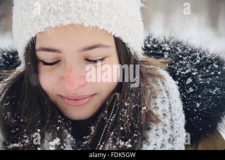 Fille souriante debout à l'extérieur dans la neige