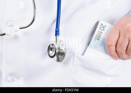 Médecin dans une tunique blanche mettre une liasse d'argent dans la poche. Banque D'Images