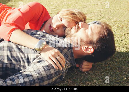 Couple lying on ground embracing Banque D'Images